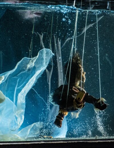 zdjęcie ze spektaklu teatru rawa angekok ujęcie bartosza sochy podczas jednej ze scen podwodnych rozgrywanych lalkami teatralnymi w akwarium